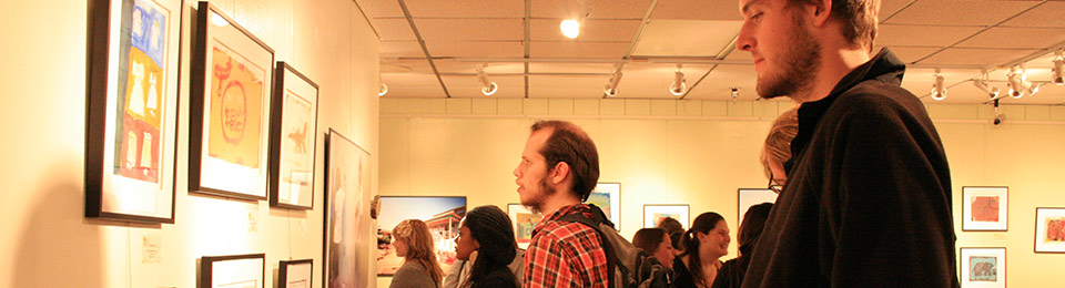 Photo of spectators admiring art displayed in the Oglesby Gallery